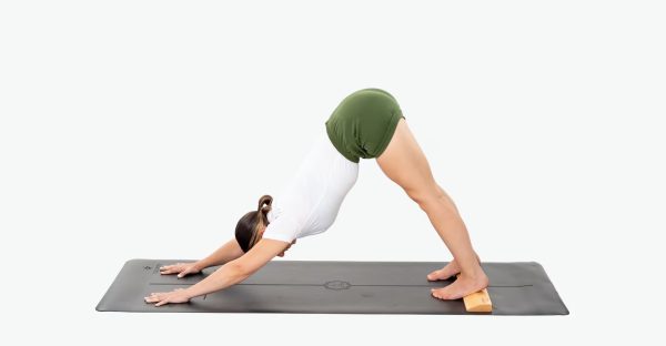 Using yoga blocks for the Downward Facing Dog pose might be too high. It is recommended to use a slanted wooden pad under the back half of the foot, which helps practitioners who cannot press down their heels to stabilize them.